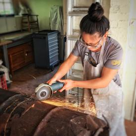 IdentityX Ambassador Trang Luu works on a horizontal cookstove for her internship in South Africa
